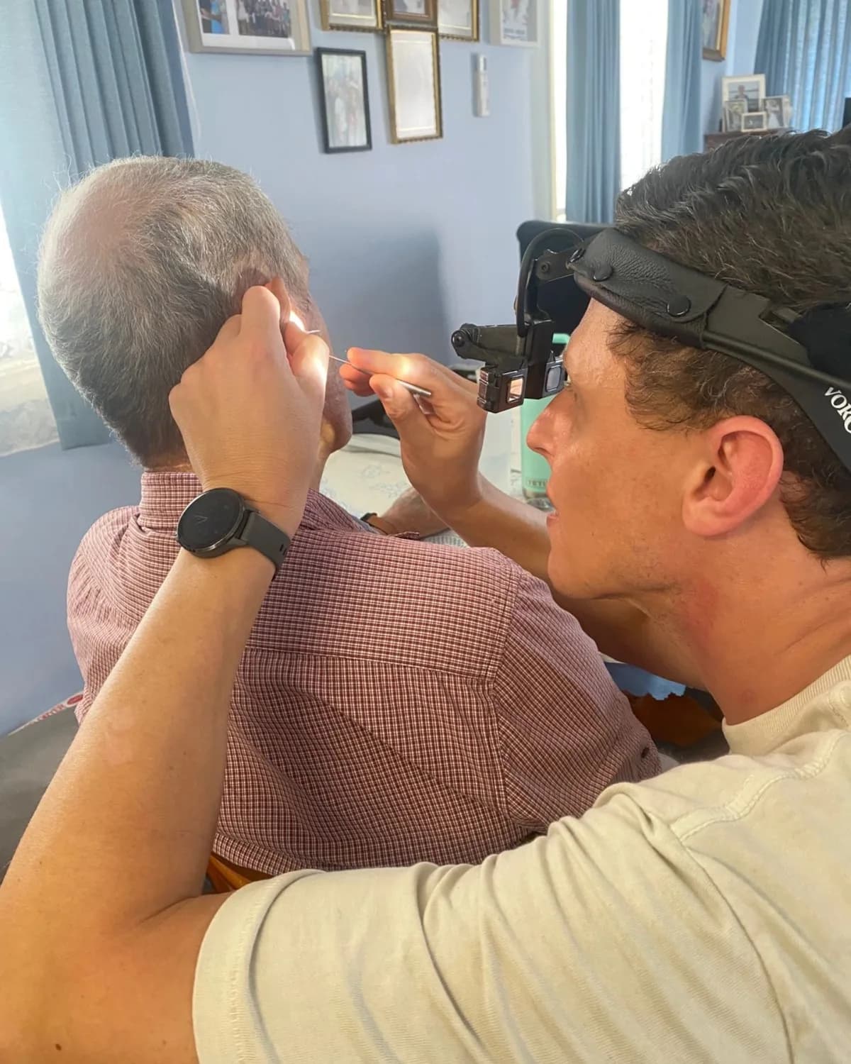 Jason Currie removing ear wax under magnification during a home visit