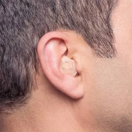 A rechargeable in-the-ear hearing aid filling the bowl of the ear